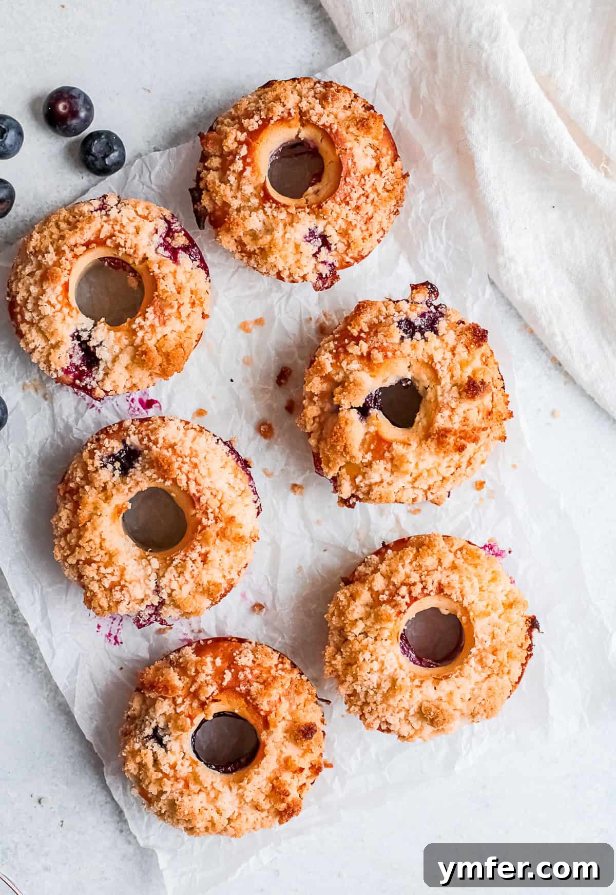 Baked Blueberry Streusel Donuts beautifully arranged on a rustic wooden table, ready to be served.