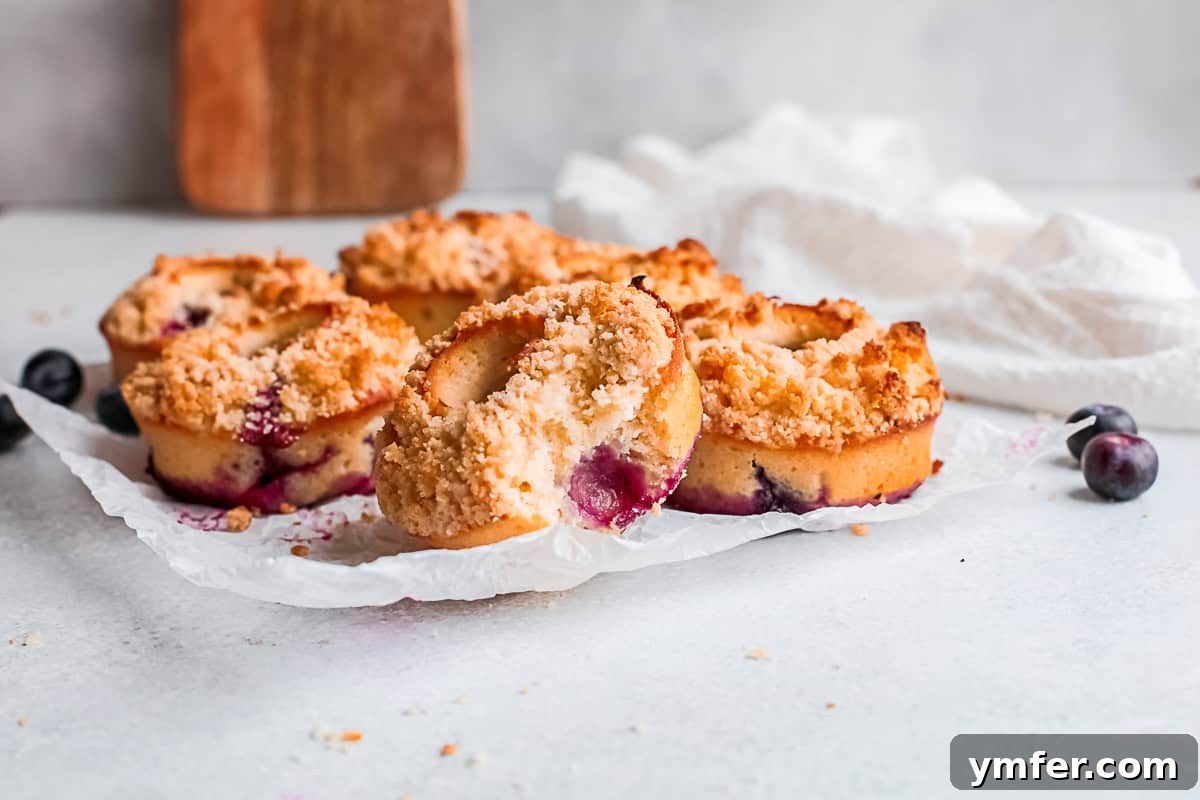 Baked Blueberry Streusel Donuts sitting on a piece of parchment paper, fresh from the oven.