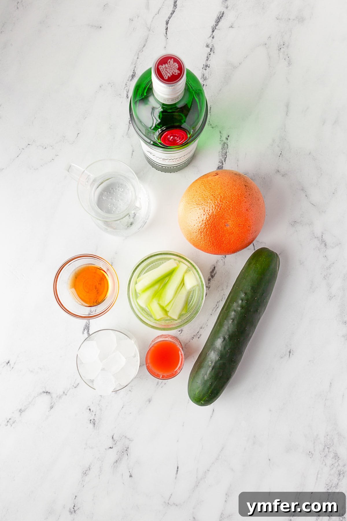 Grapefruit Gin Sparkler 3 Ingredients for Grapefruit Gin Fizz laid out on a table, including gin, grapefruit, seltzer, and agave.