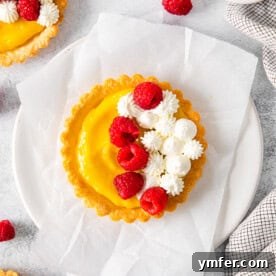 Sunshine Lemon Tarts 11 A delectable lemon curd tart, topped with fresh raspberries and whipped cream, captured beautifully.