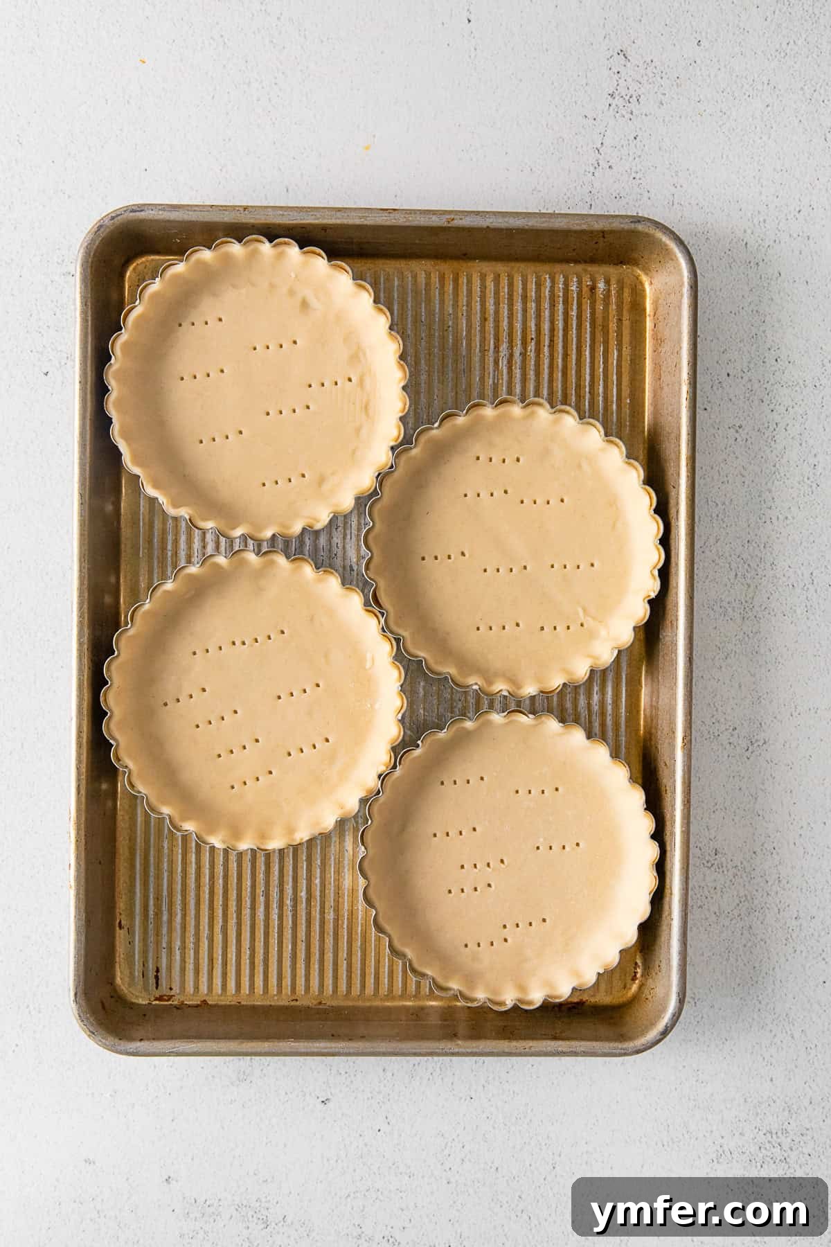 Sunshine Lemon Tarts 5 Mini tart pans lined with uncooked pie crust, blind-baked and ready for filling.