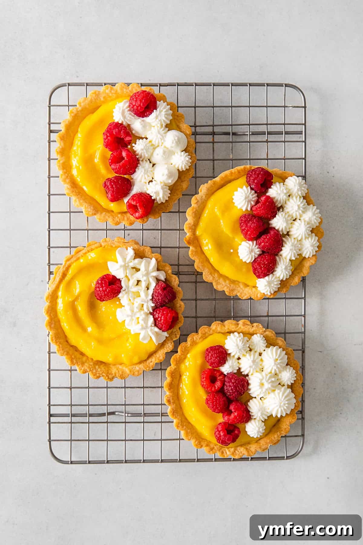 Sunshine Lemon Tarts 6 Baked lemon curd tarts cooling on a wire rack, ready to be topped.