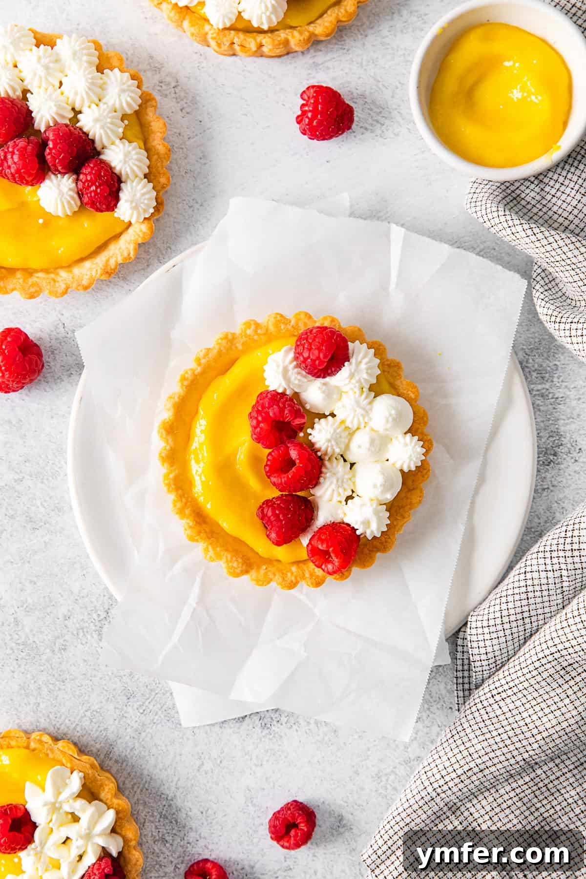Sunshine Lemon Tarts 8 Lemon Curd Tarts with elegant swirls of whipped cream, showcasing a refined presentation.