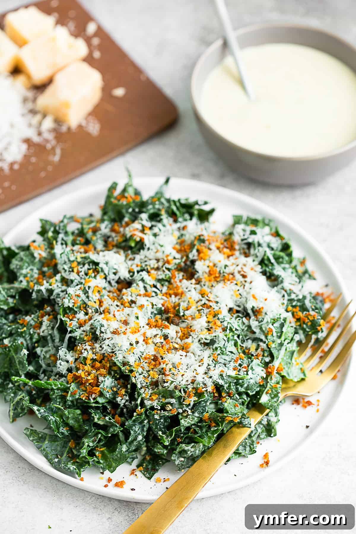 Zesty Chopped Kale Caesar 4 Chopped Kale Caesar Salad on a plate with extra dressing and cheese.