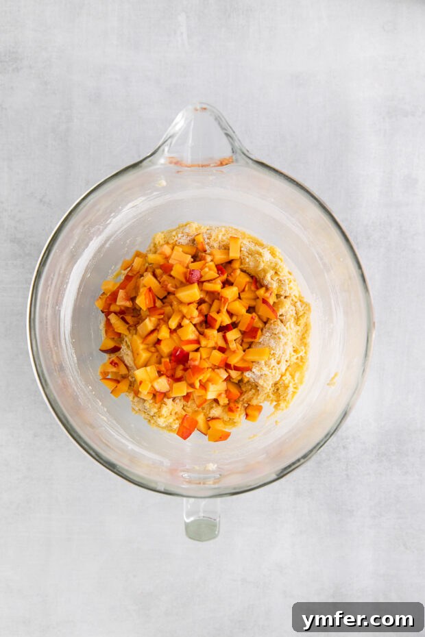 Sun-Kissed Peach Pound Cake 5 Fresh chopped peaches in a bowl of pound cake batter.