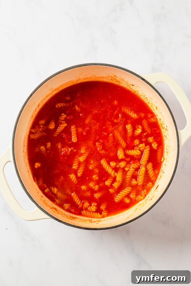 Zesty Skillet Chicken Fajita Pasta 4 Pasta cooking in a pot with tomatoes and other fajita ingredients.