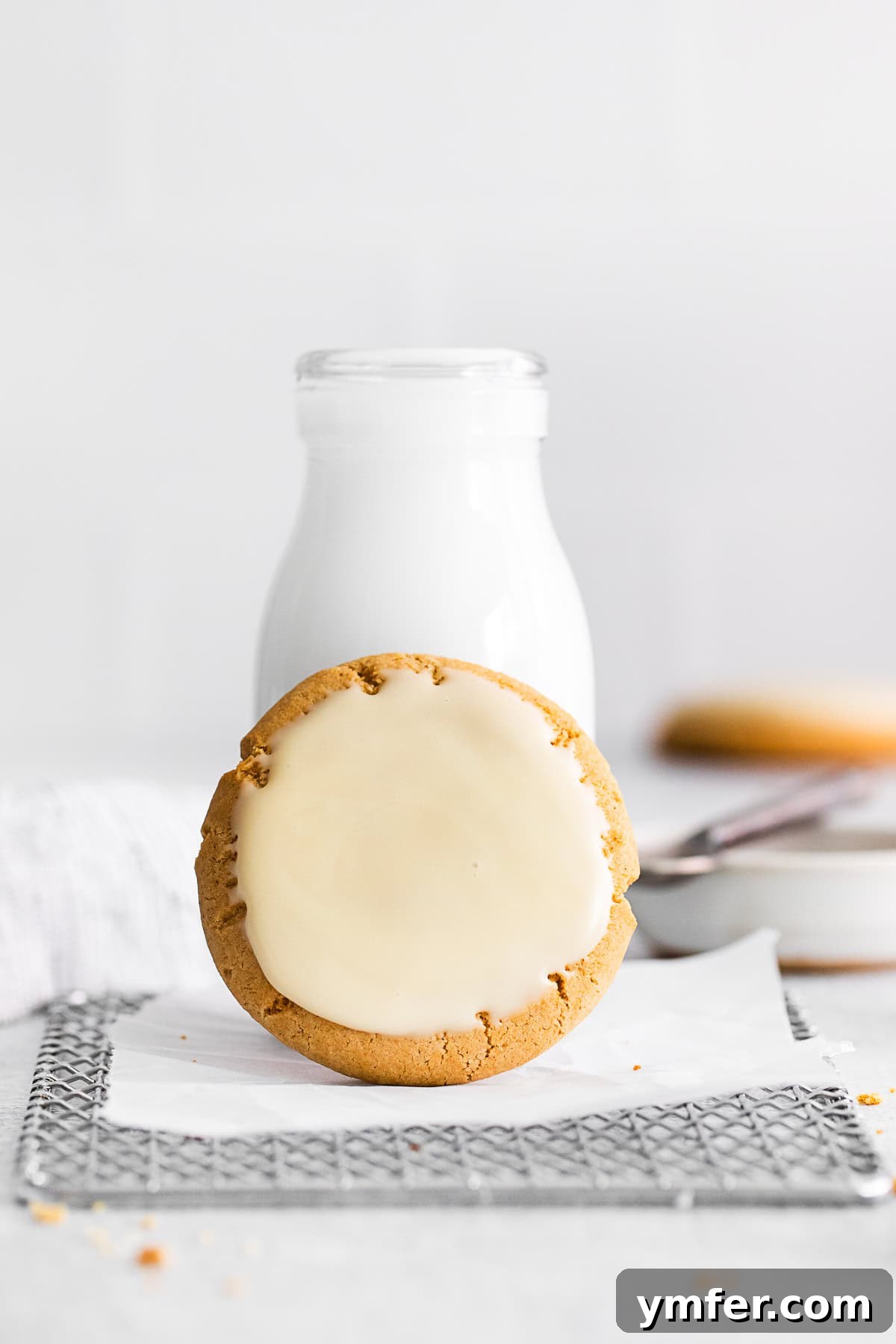 Maple Drizzle Delights 8 A maple glazed cookie resting casually on a bottle of milk, highlighting a perfect pairing.