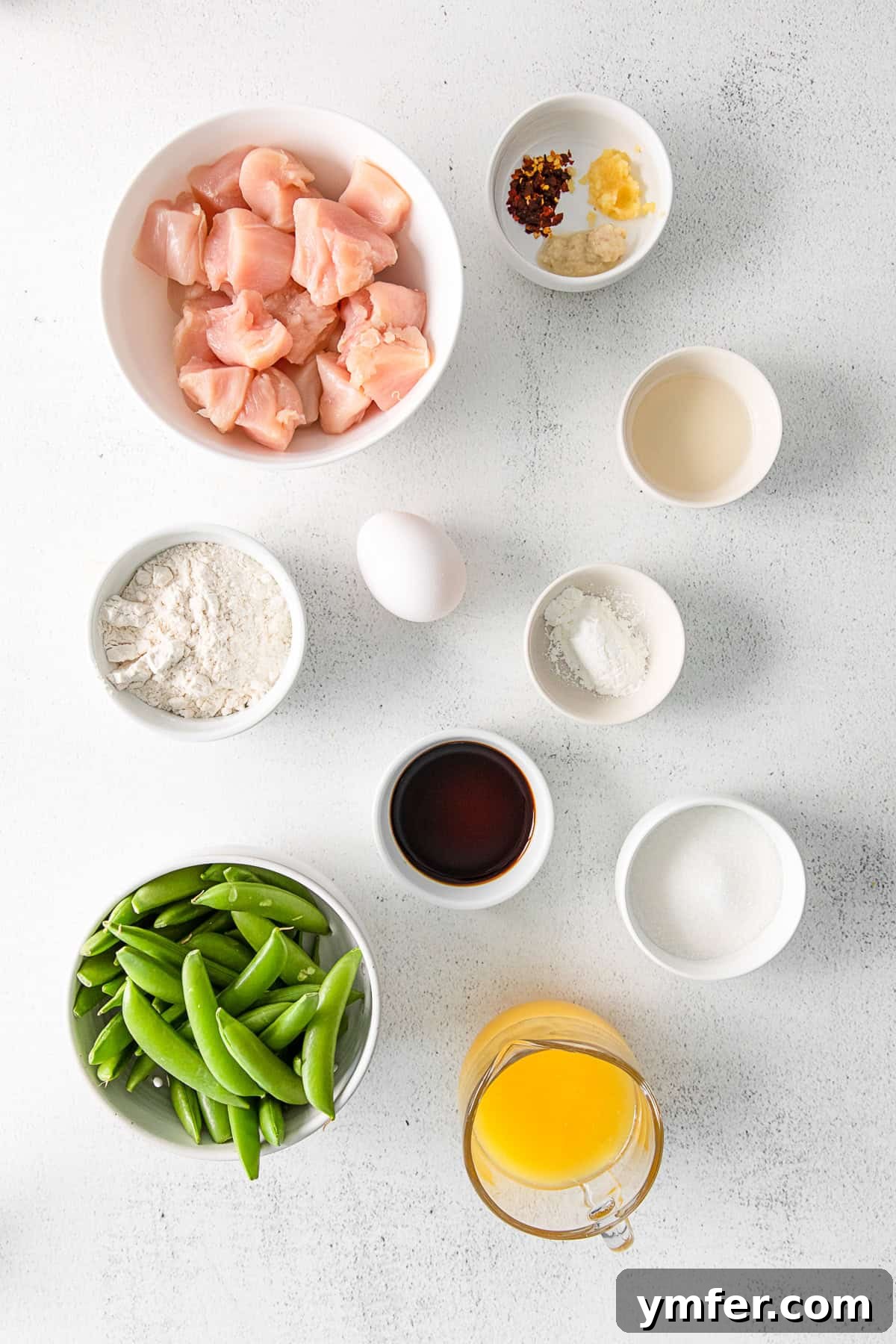 Simple Sheet Pan Sticky Orange Chicken 3 Sheet Pan Orange Chicken ingredients laid out on a table for preparation.