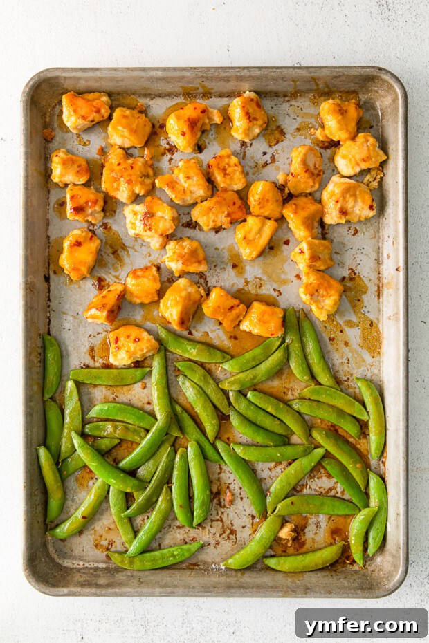 Simple Sheet Pan Sticky Orange Chicken 5 Sheet Pan Orange Chicken, with chicken and sugar snap peas, cooked on a sheet pan.