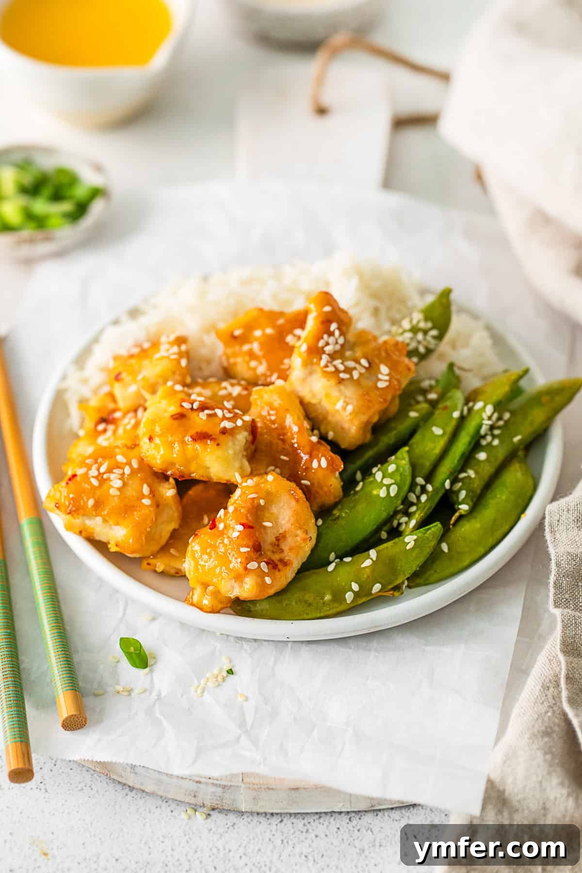 Simple Sheet Pan Sticky Orange Chicken 6 Sheet Pan Orange Chicken topped with sesame seeds, ready to be served.