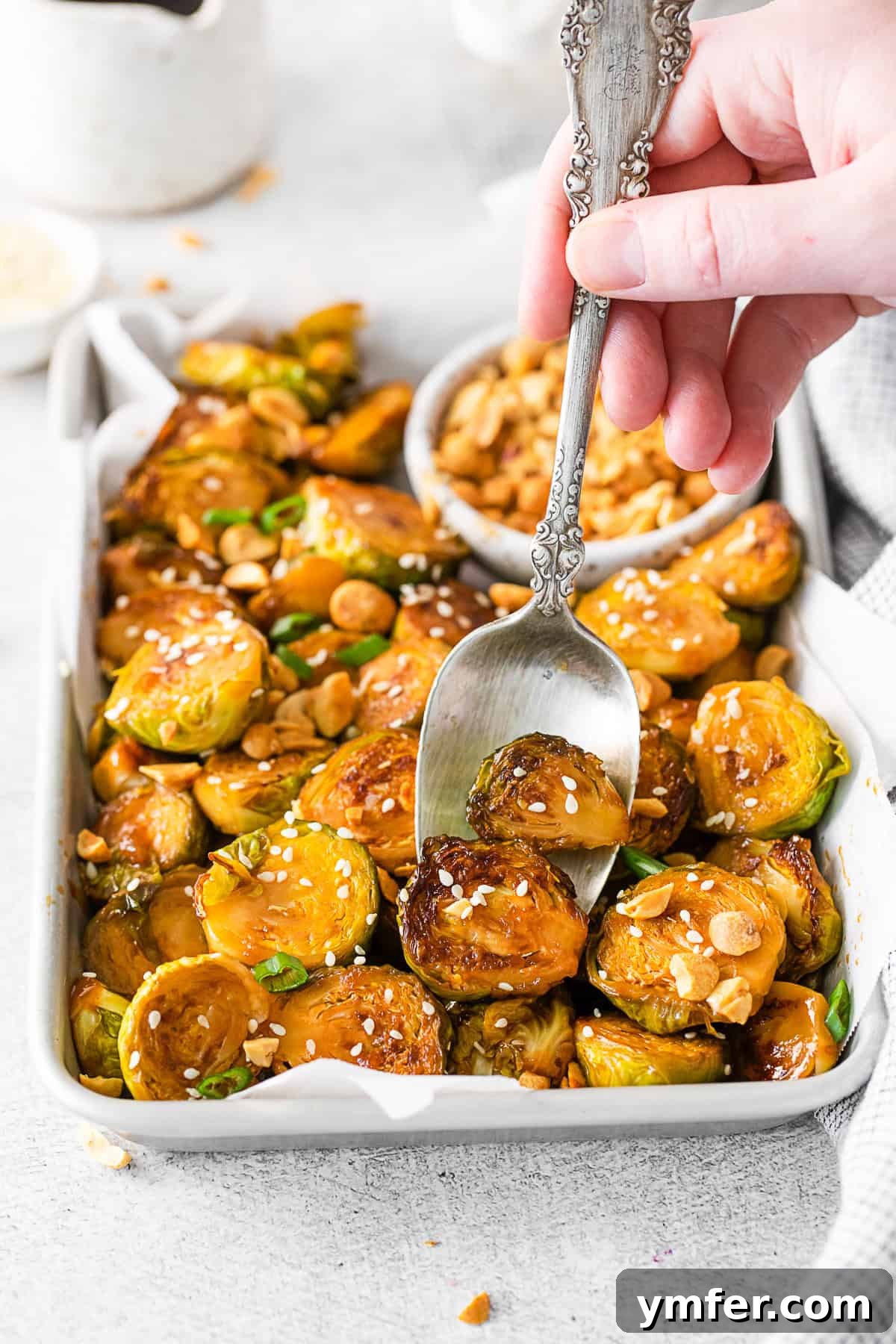 Kung Pao'd Brussels Sprouts 8 A spoon taking a serving of Kung Pao Brussels Sprouts from a pan.