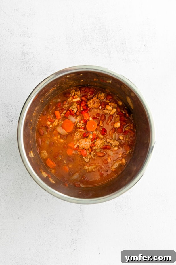 Hearty Instant Pot Turkey Chili 5 Ground turkey browning in an Instant Pot with sautéed vegetables.