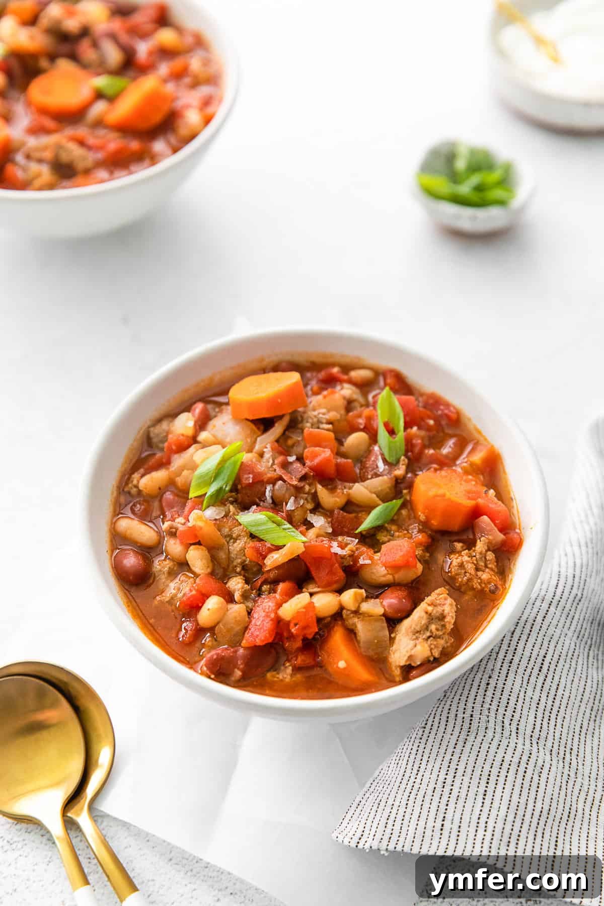 Hearty Instant Pot Turkey Chili 6 A bowl of Instant Pot Turkey Chili with a variety of toppings like shredded cheese, sour cream, and fresh herbs.