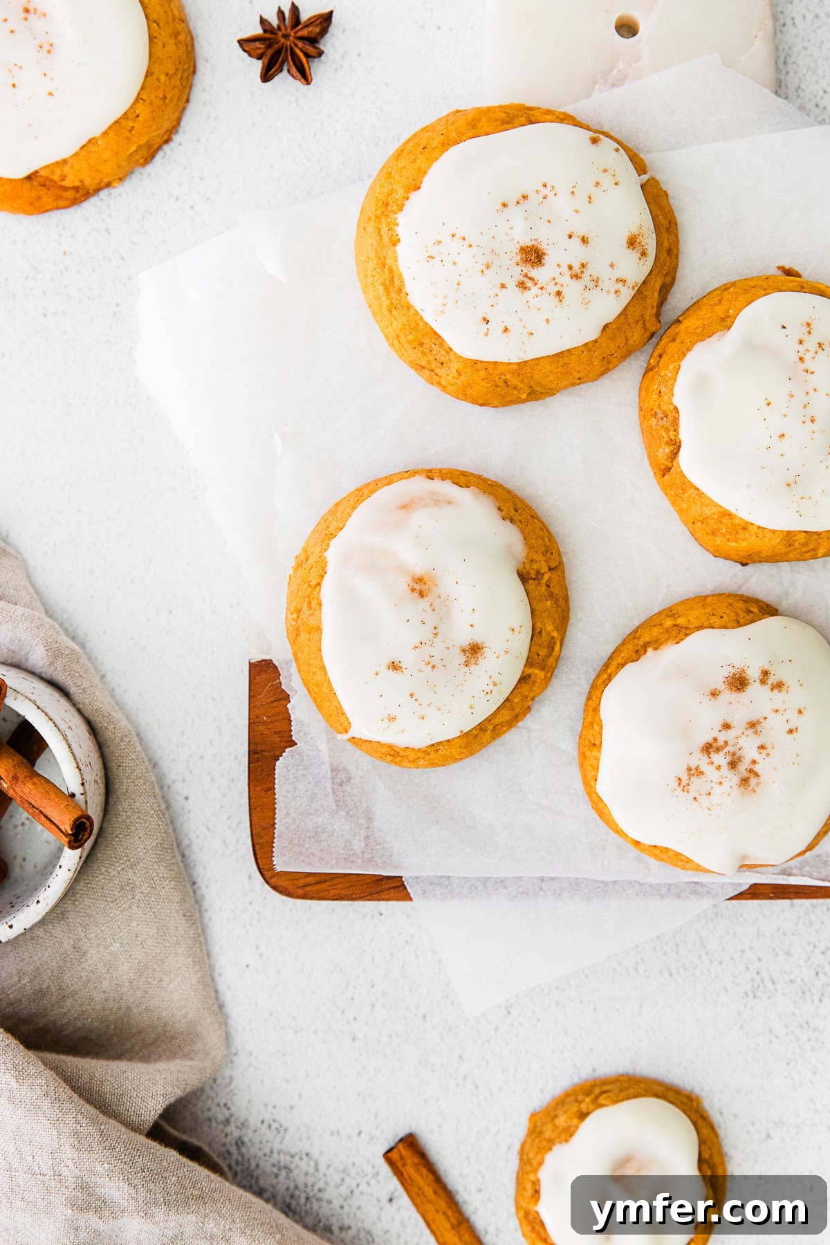 Cozy Fall Pumpkin Cookies 2 Soft Pumpkin Cookies topped with a generous swirl of cream cheese frosting and a sprinkle of cinnamon, perfect for fall.