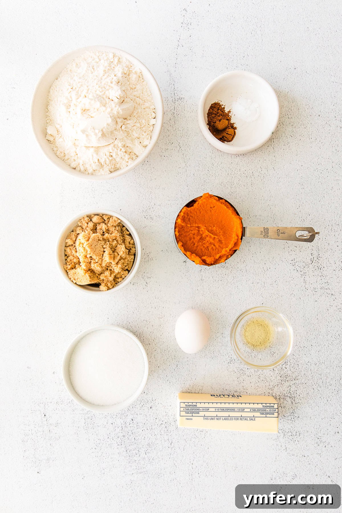 Cozy Fall Pumpkin Cookies 3 Various ingredients for Soft Pumpkin Cookies laid out on a rustic wooden table, including flour, sugar, butter, and pumpkin puree.