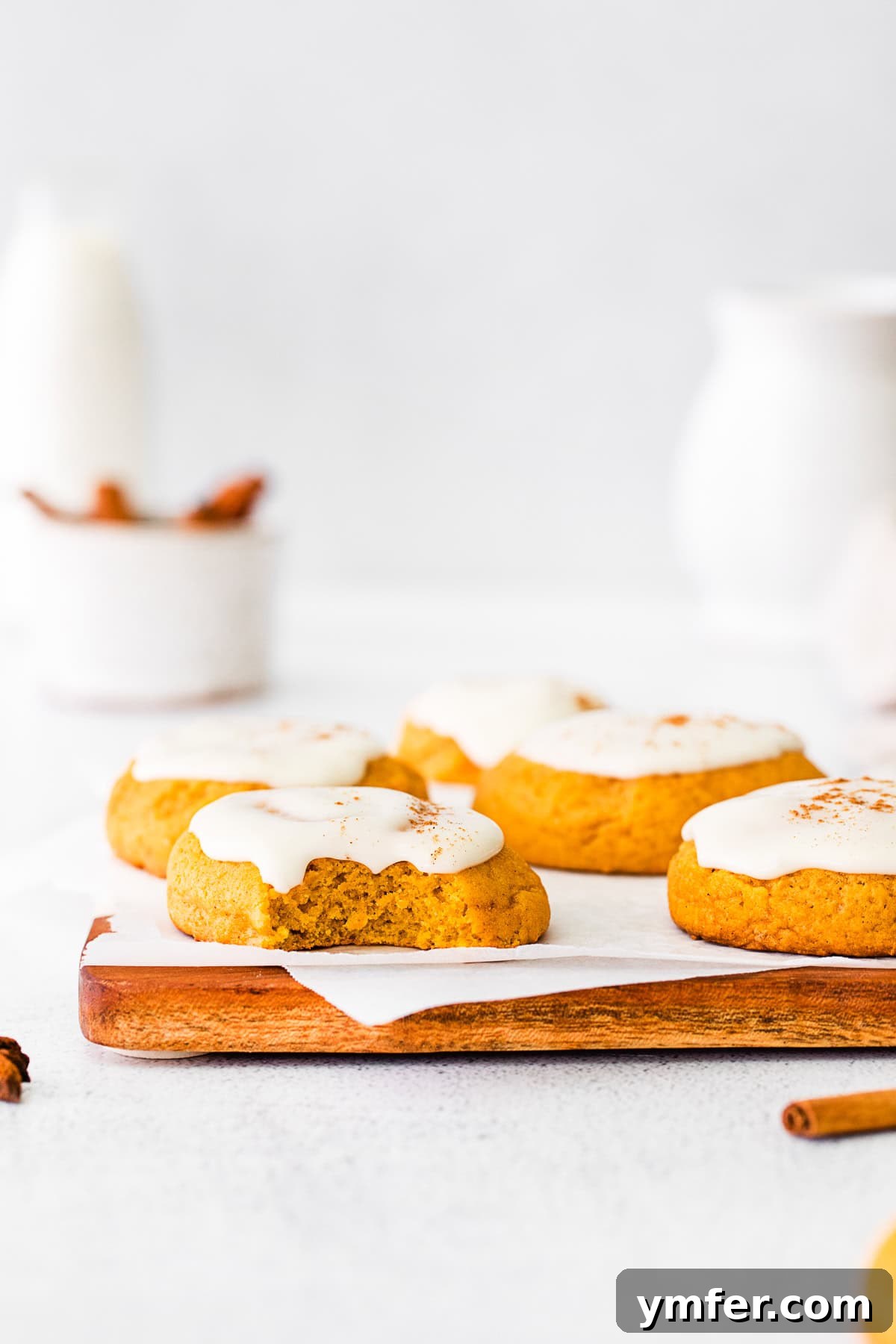Cozy Fall Pumpkin Cookies 6 A Soft Pumpkin Cookie with a small bite taken out, revealing its tender, moist interior and generous frosting.