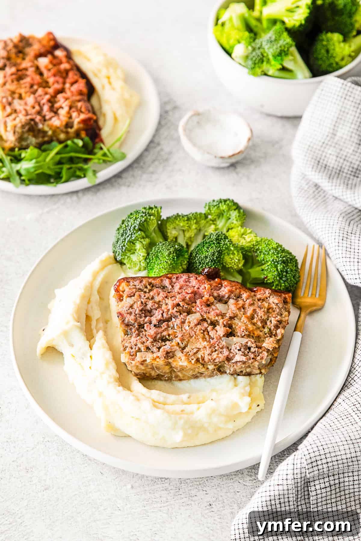 Smoky BBQ Glazed Meatloaf 6 A generous serving of BBQ Glazed Meatloaf alongside creamy mashed potatoes on a plate.