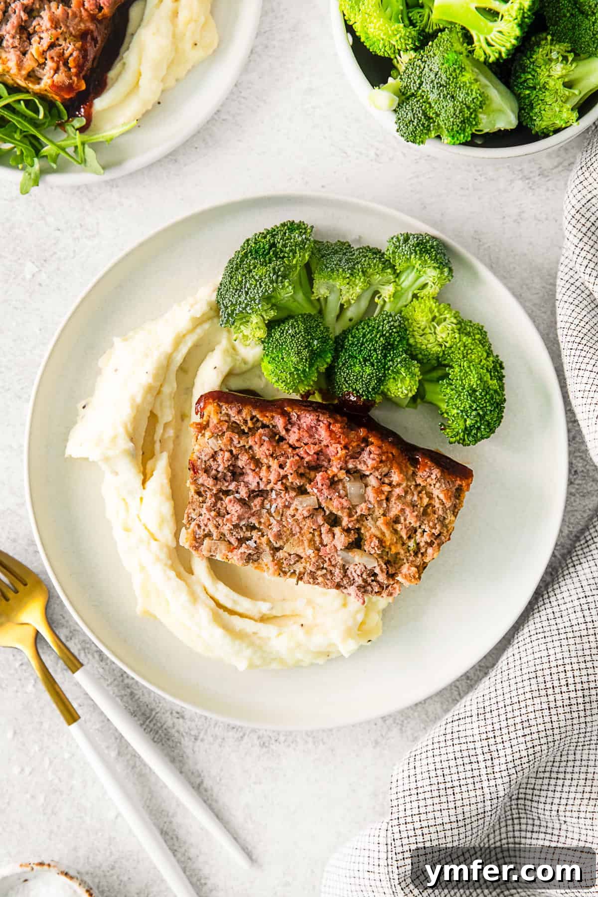 Smoky BBQ Glazed Meatloaf 7 A whole BBQ Glazed Meatloaf on a white platter, garnished with fresh parsley.
