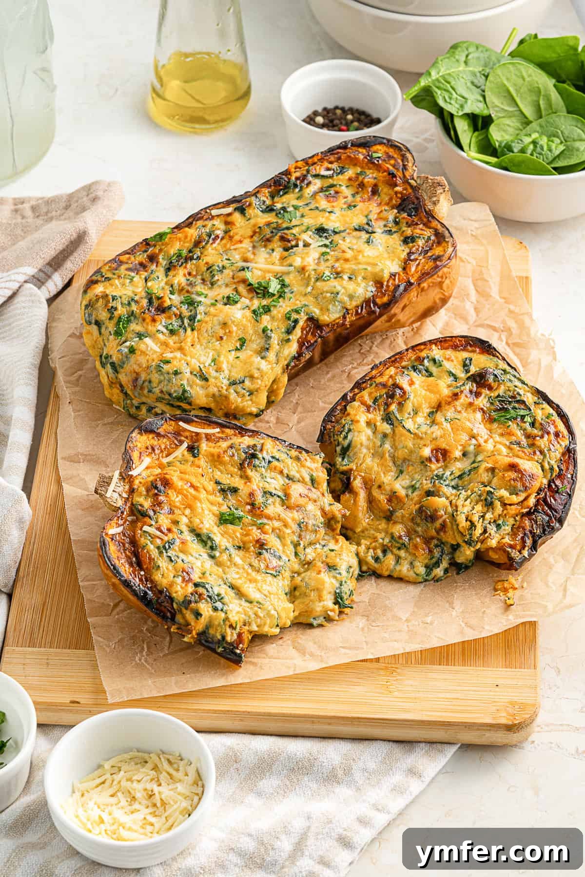 Creamy Cheesy Butternut Squash Bake 8 Two halves of Cheese Stuffed Butternut Squash on a rustic cutting board, garnished with fresh herbs.