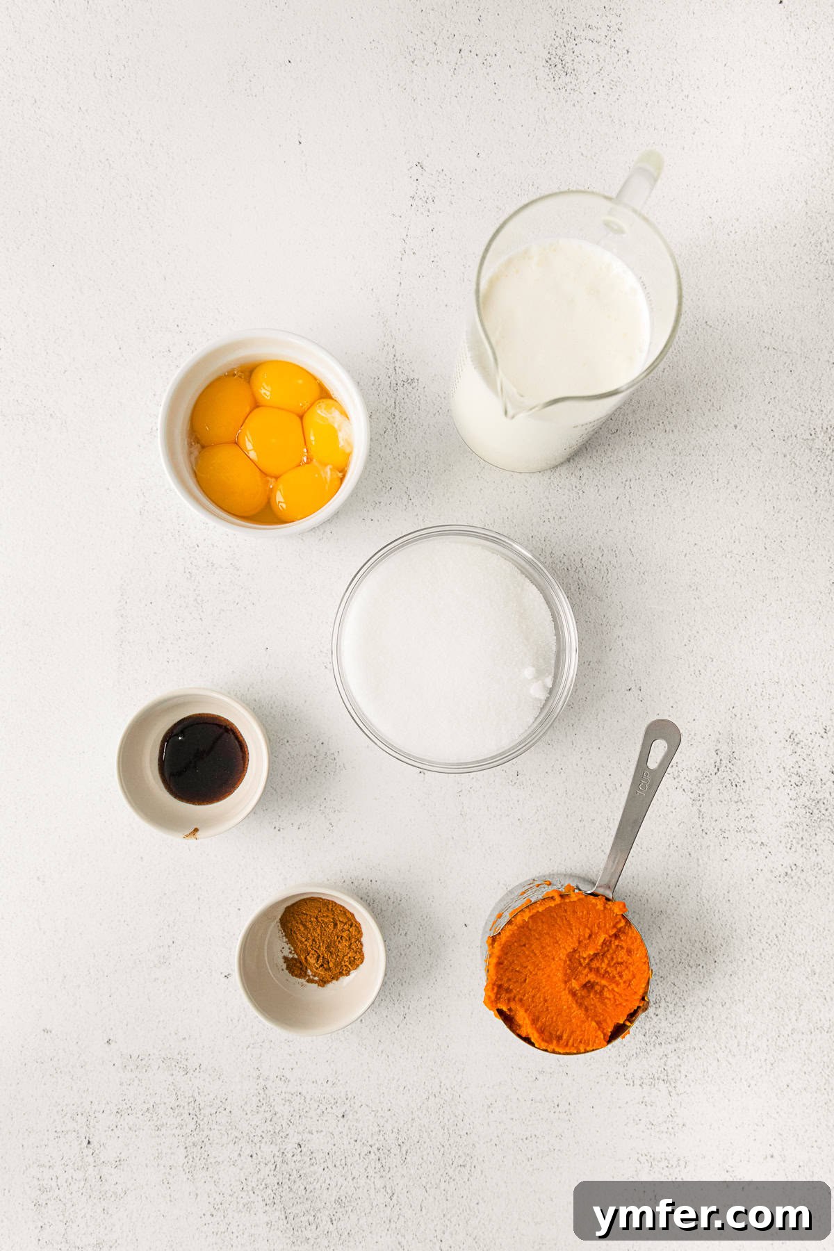 Spiced Pumpkin Creme Brulee 3 Ingredients for Pumpkin Creme Brulee, neatly arranged on a rustic wooden table.