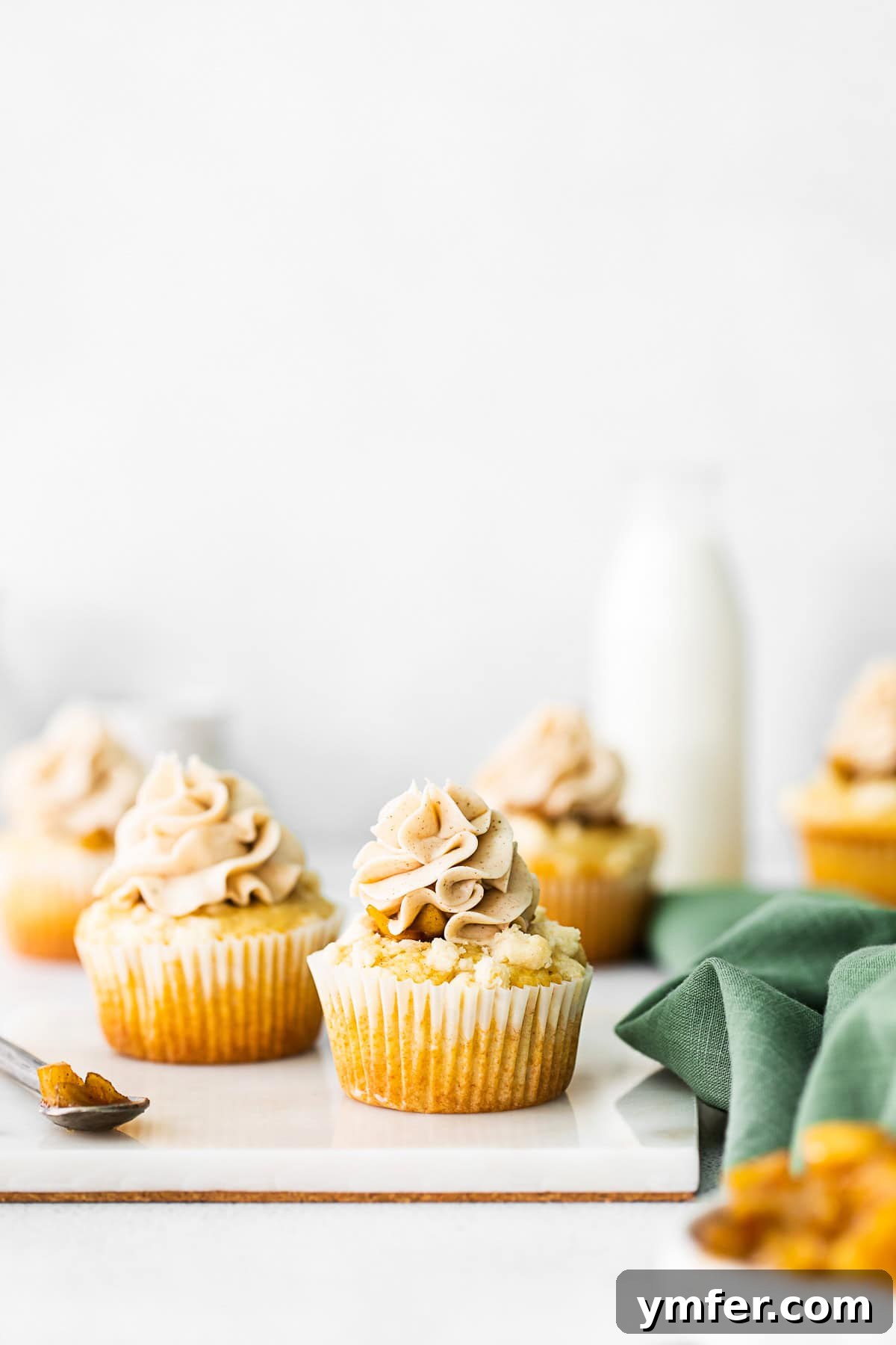 Cinnamon Apple Pie Cupcakes 2 Delicious Apple Pie Cupcakes topped with spiced buttercream frosting and streusel crumbs, ready to be enjoyed.