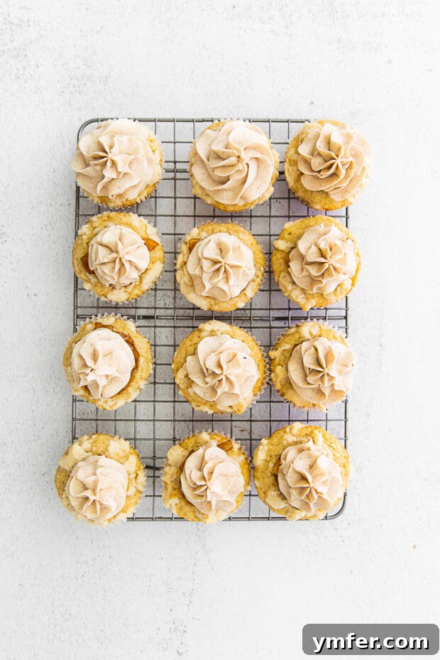 Cinnamon Apple Pie Cupcakes 6 Freshly baked Apple Pie Cupcakes cooling on a wire rack, with golden streusel topping visible.