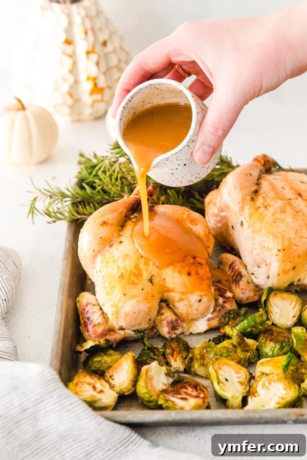 An easy sheet pan Thanksgiving dinner featuring roasted Cornish hens, sweet potato casserole, stuffing, and Brussels sprouts, perfect for small gatherings.