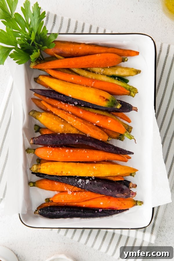 A Feast of Thanksgiving Sides 17 Vibrant honey roasted carrots glistening on a white serving dish.