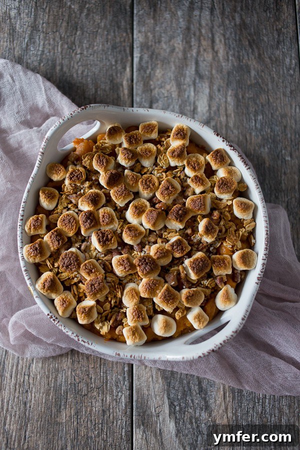 A Feast of Thanksgiving Sides 25 Creamy Vanilla Bean Sweet Potato Casserole topped with crunchy granola in a round baking dish.