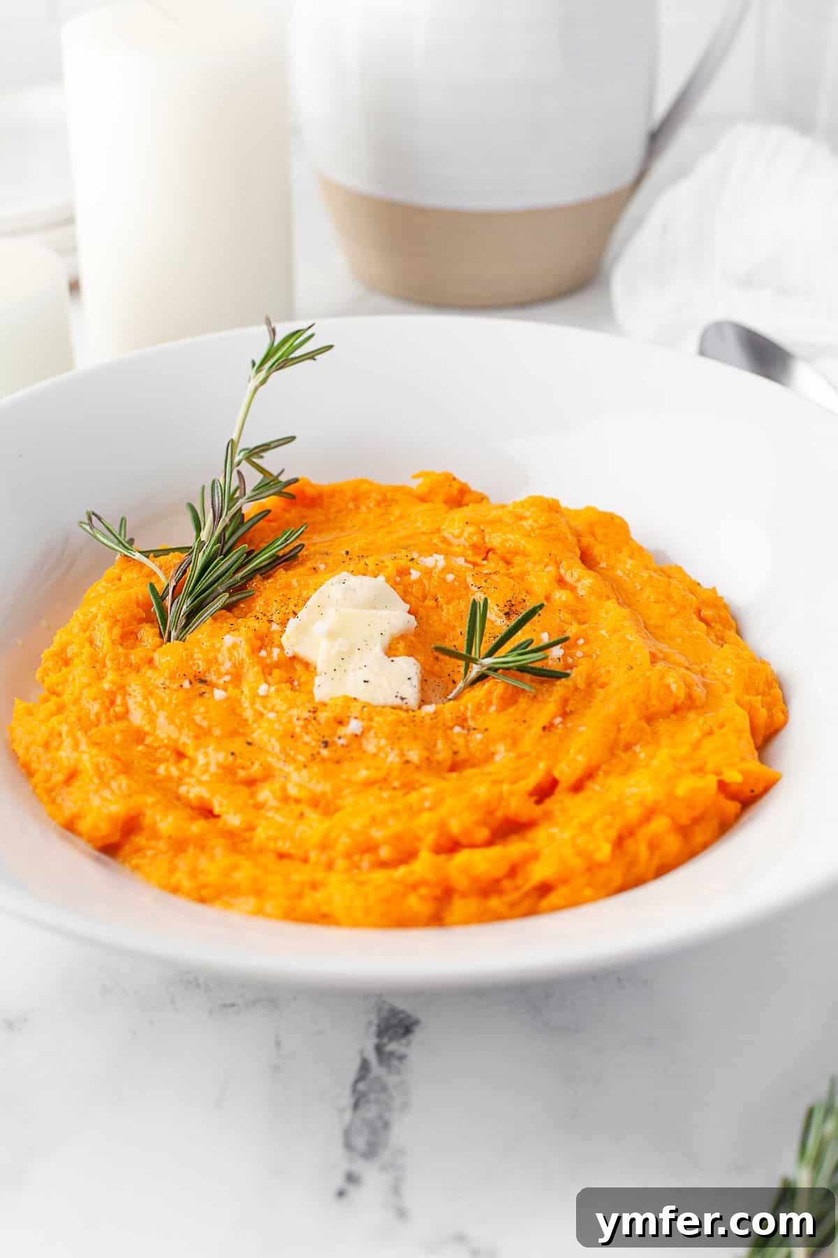 Creamy Instant Pot Butternut Mash 6 A bowl of creamy Instant Pot Mashed Butternut Squash, garnished with fresh rosemary.