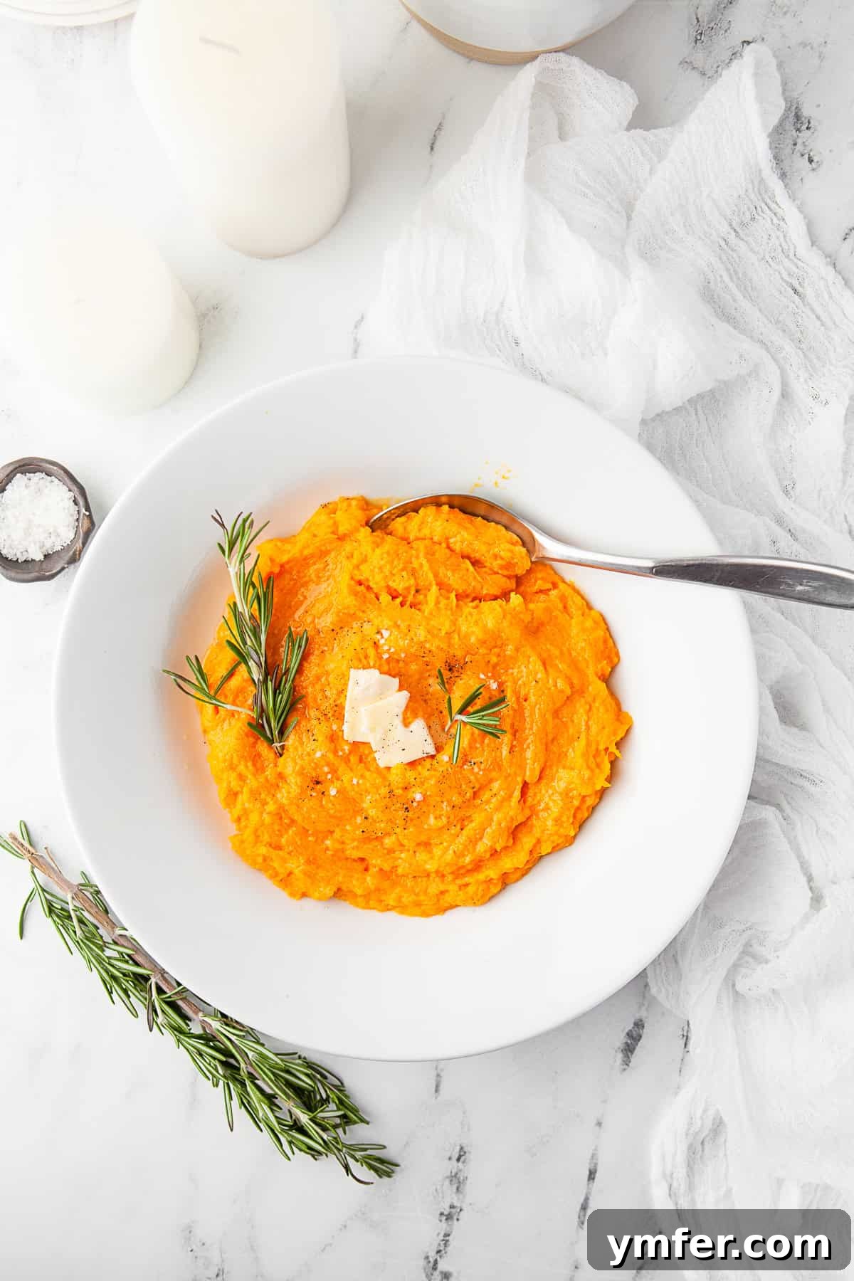 Creamy Instant Pot Butternut Mash 7 A serving of Instant Pot Mashed Butternut Squash next to roasted meat, garnished with fresh herbs.