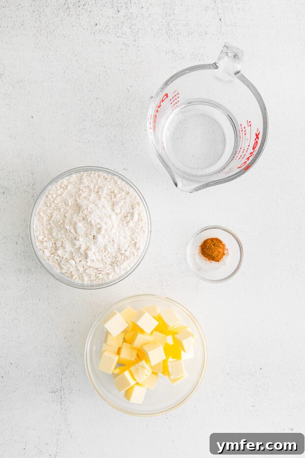 Ingredients for a buttery, flaky pie dough laid out on a kitchen counter.