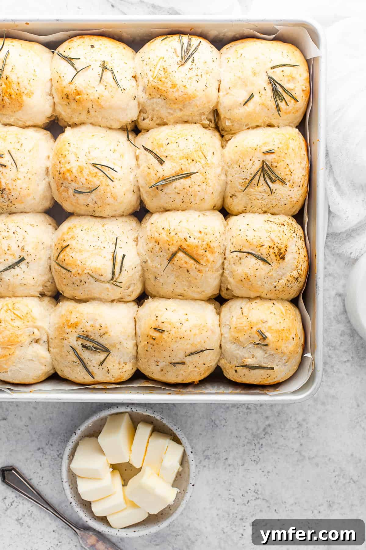 Warm Garlic Herb Rolls 7 A baking tray filled with golden-brown, freshly baked Garlic Herb Dinner Rolls, just out of the oven and cooling.