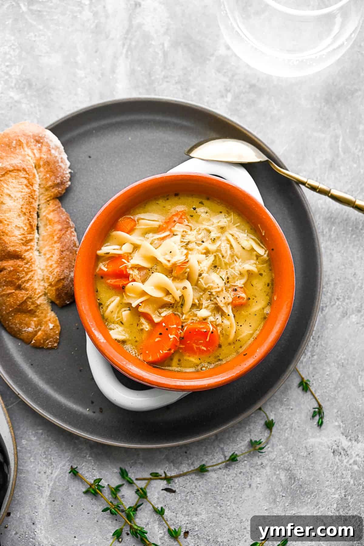 Turkey Noodle Soup Revival 6 A bowl of Leftover Turkey Noodle Soup served with a slice of rustic bread, perfect for a cozy meal.
