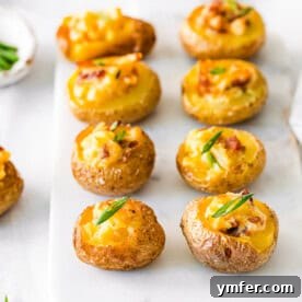 Mini Loaded Baked Potatoes topped with chives, ready to be served from a recipe card.