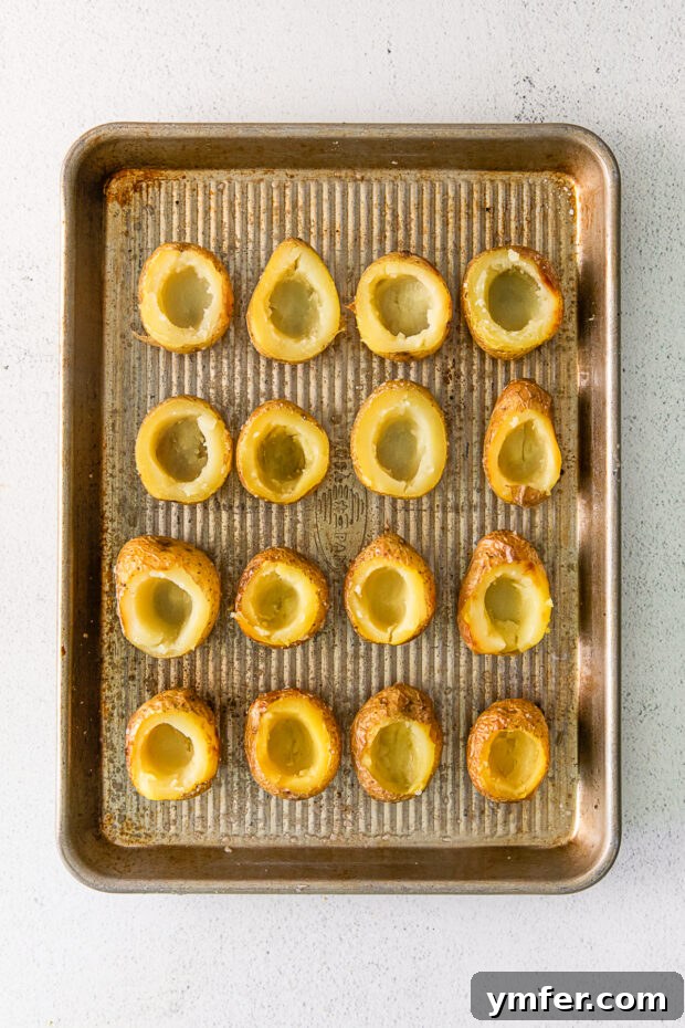 Tiny Tater Toppers 4 Close-up of small, baked potatoes with their centers carefully scooped out, ready for filling.