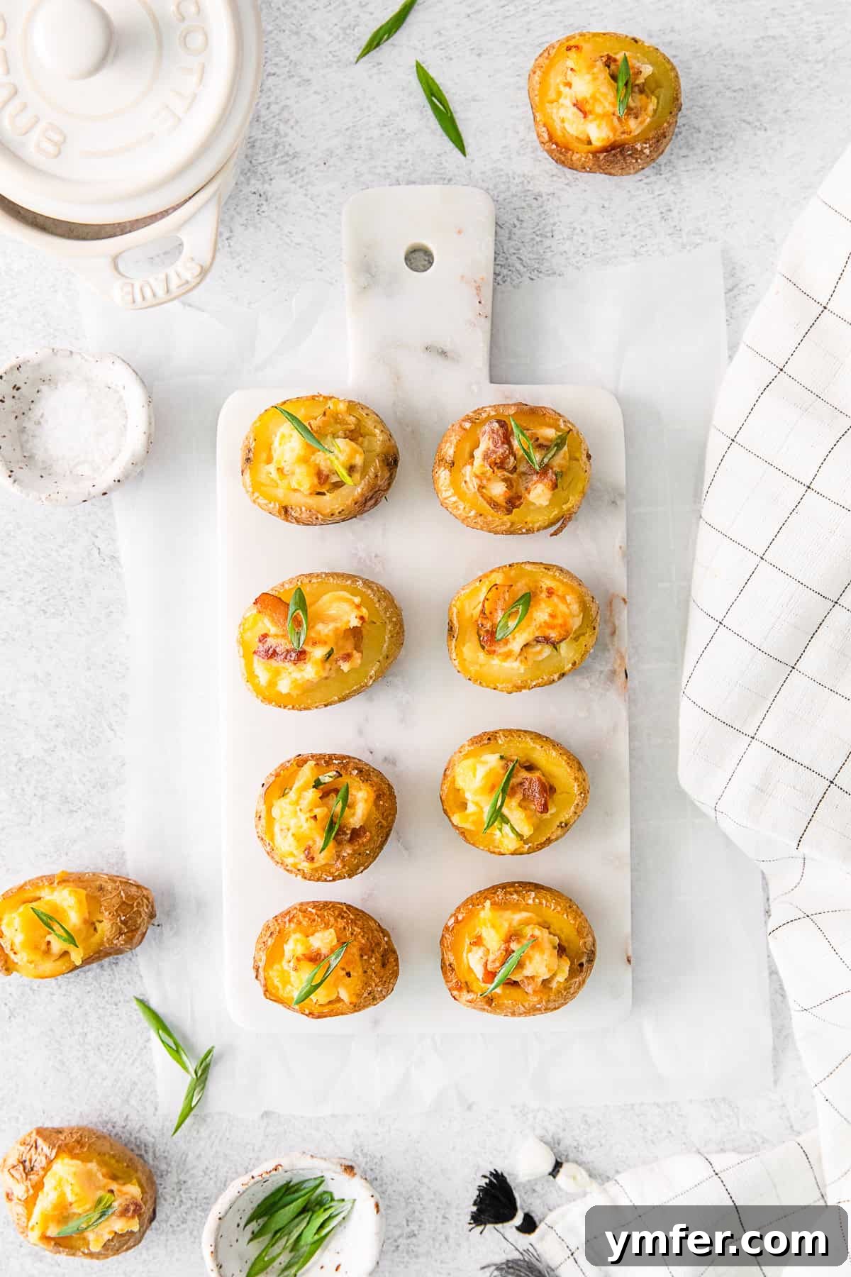 Tiny Tater Toppers 9 A elegant serving tray laden with perfectly arranged Mini Loaded Baked Potatoes, garnished with fresh herbs, ready for a festive gathering.