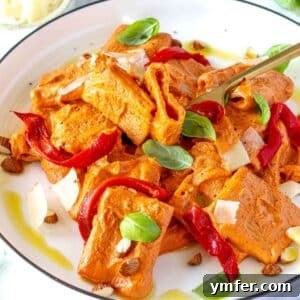 Vibrant Red Pepper Pasta 9 Roasted red pepper pasta served on a plate with basil garnish.