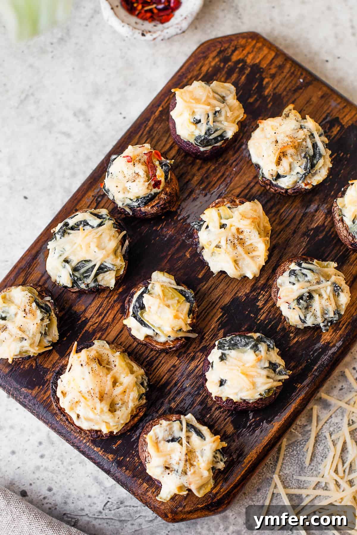 Cheesy Spinach Artichoke Stuffed Mushroom Caps 2 Spinach Artichoke Stuffed Mushrooms topped with cheese.