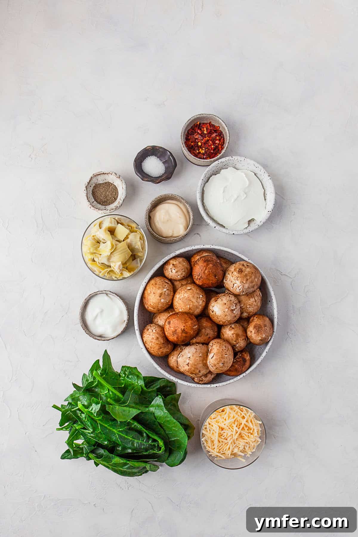 Cheesy Spinach Artichoke Stuffed Mushroom Caps 3 Ingredients to make Spinach Artichoke Stuffed Mushrooms on a table.