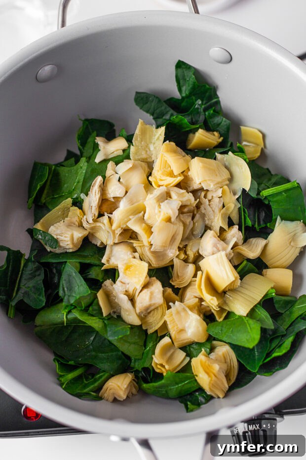 Cheesy Spinach Artichoke Stuffed Mushroom Caps 4 Spinach and artichokes in a pan.