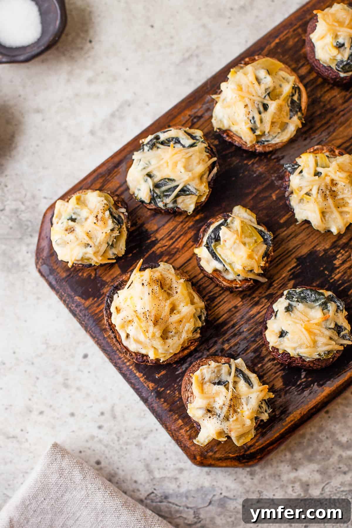 Cheesy Spinach Artichoke Stuffed Mushroom Caps 9 Spinach Artichoke Stuffed Mushrooms topped with Parmesan cheese.