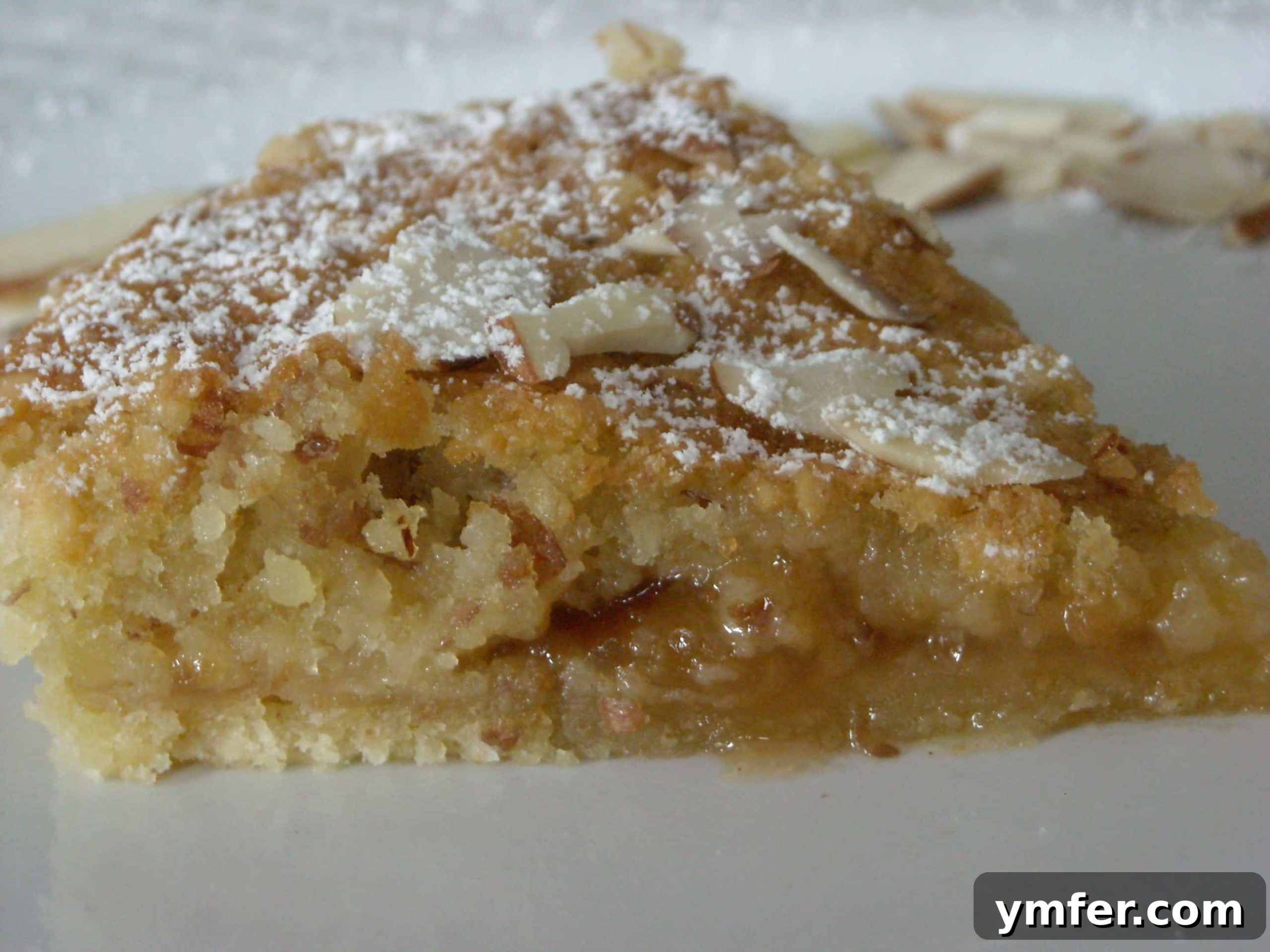 Slice of Bakewell Tart showing layers of crust, jam, and frangipane