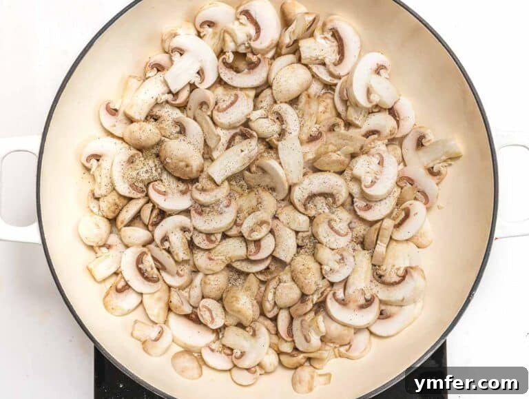 Mushrooms cooking in a skillet with olive oil