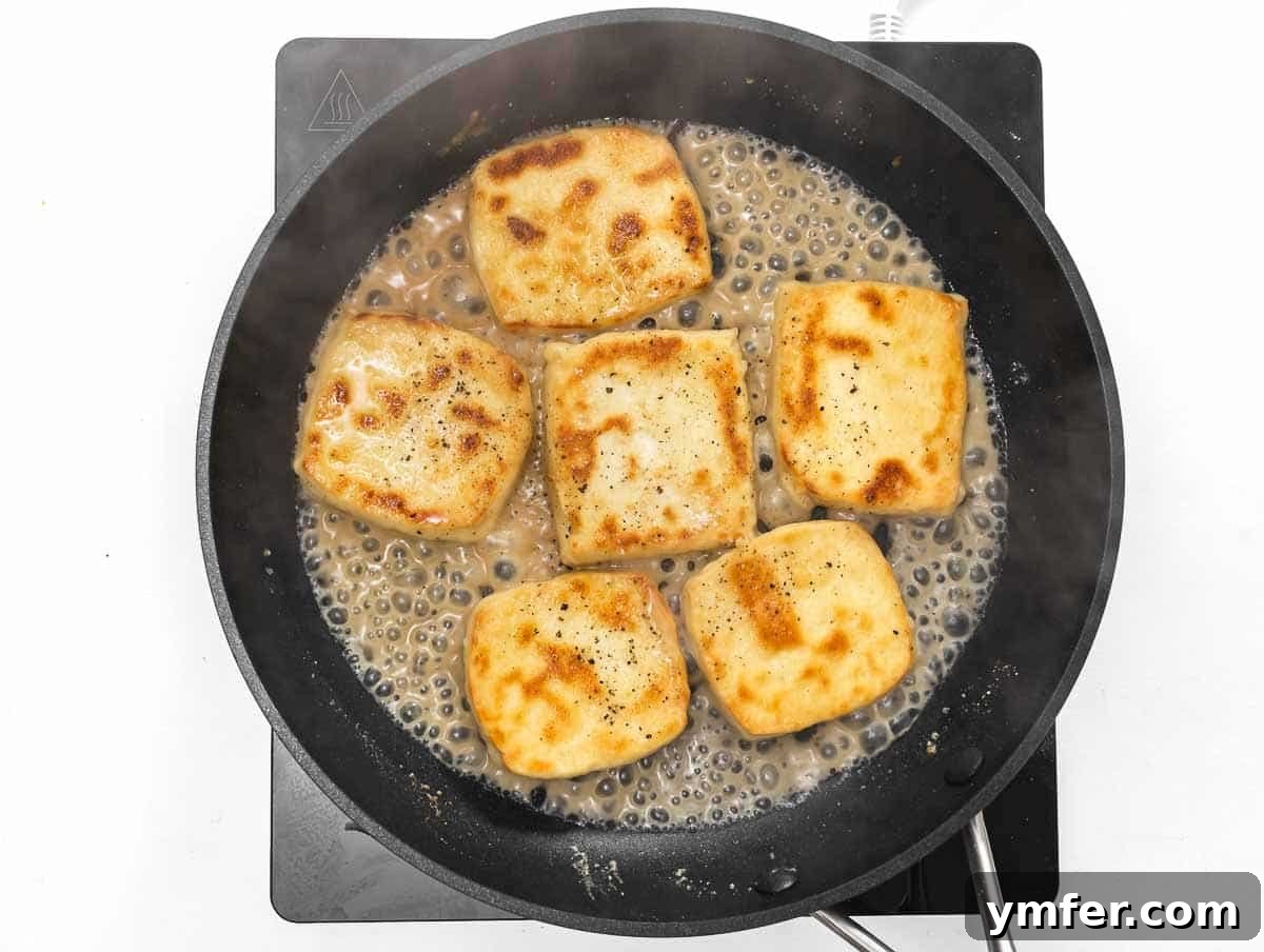 Flavorful Tofu Mushroom Medley 12 White wine being added to the pan with frying tofu.