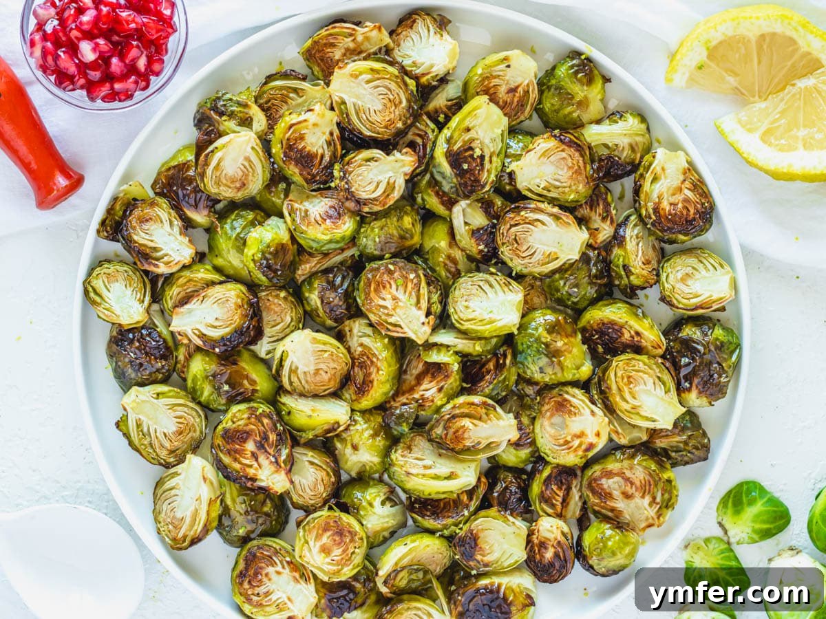 Crispy Roasted Brussels Sprouts 11 A serving platter of roasted Brussels Sprouts, beautifully arranged with lemon wedges and ready to be served.