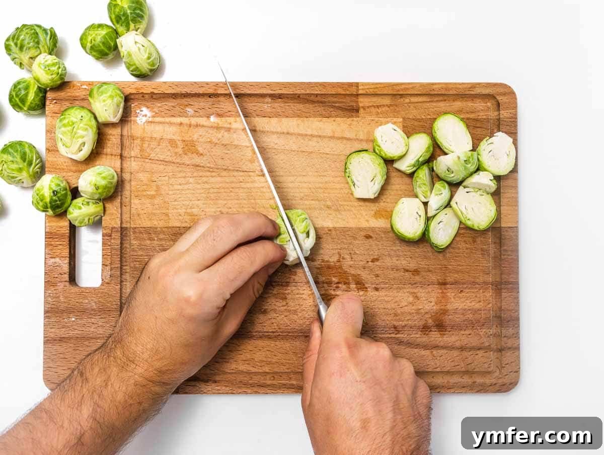 Crispy Roasted Brussels Sprouts 8 A cutting board with several Brussels sprouts, some whole, some neatly cut in half lengthwise.