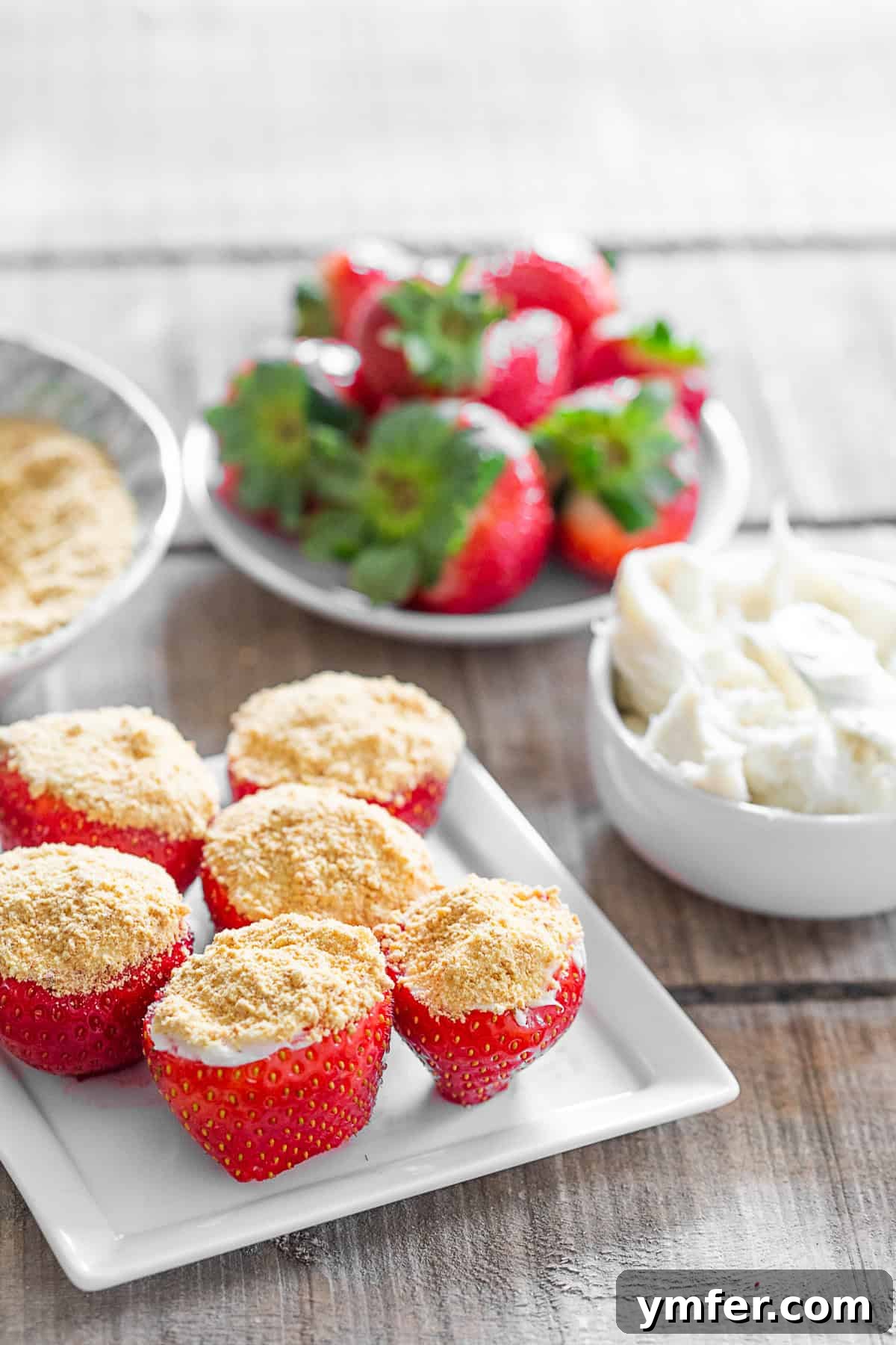 Strawberry Cheesecake Bliss Bites 2 Cheesecake Stuffed Strawberries on a small white plate.