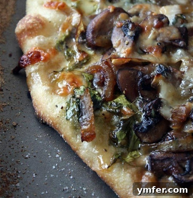 Gourmet Lamb's Quarters Pizza with Caramelized Onions and Mushrooms 4 Close-up of a delicious caramelized onion, mushroom, and lamb's quarters pizza, ready to be sliced.