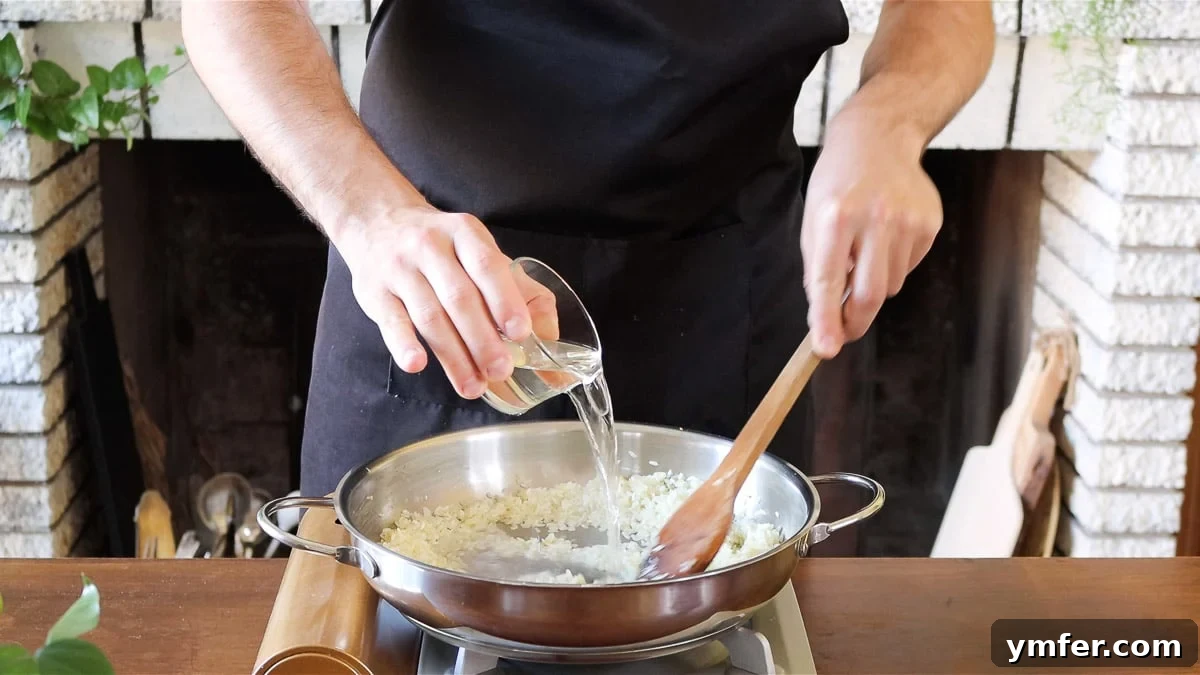 Effortless Plant-Based Risotto 11 Risotto rice being deglazed with white wine in a pot.
